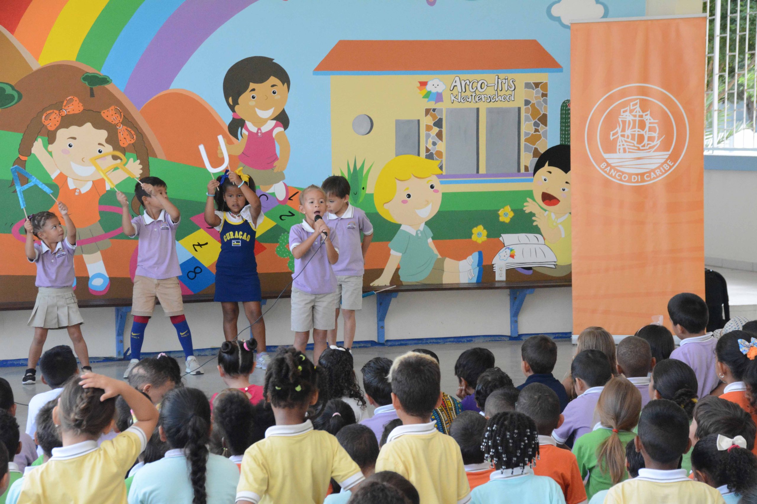 Banco di Caribe a entrega premio na muchanan sobresaliente den Festival di Canto Bos Escolar